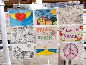 Nine small cards with colorful drawings, including images of hearts, peace signs, and doves.
