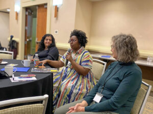 A woman speaks into a microphone in a workshop at the Annual Race Amity Conference held by the National Center for Race Amity