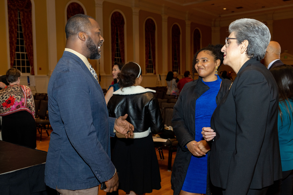 Three diverse meeting participants converse at the annual Bahá'í Chair for World Peace lecture.