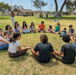 large diverse group sitting in a circle outside