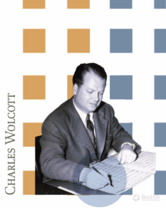 Charles Wolcott, with decorative boxes behind him. he is signing a document.